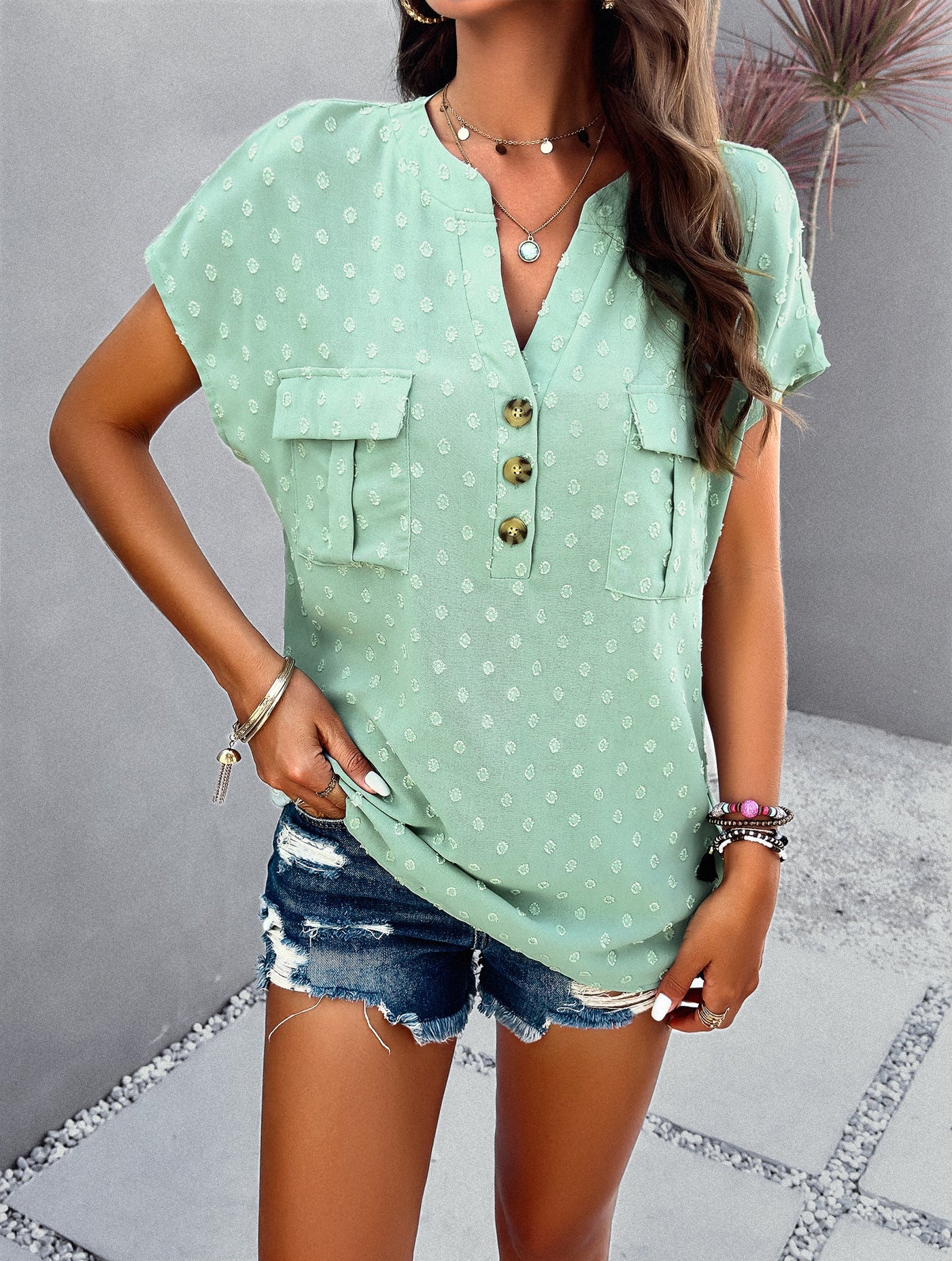 Blusa de manga corta con lunares texturizados y bolsillos delanteros