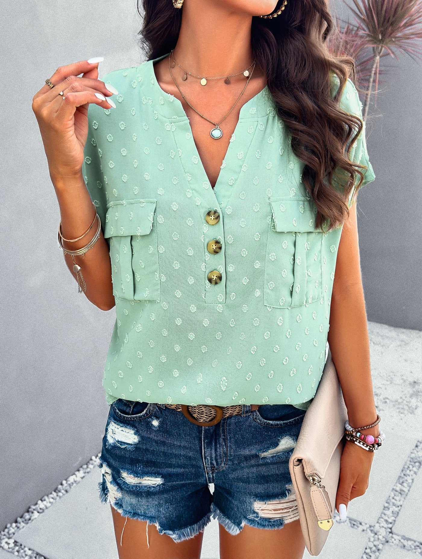 Blusa de manga corta con lunares texturizados y bolsillos delanteros